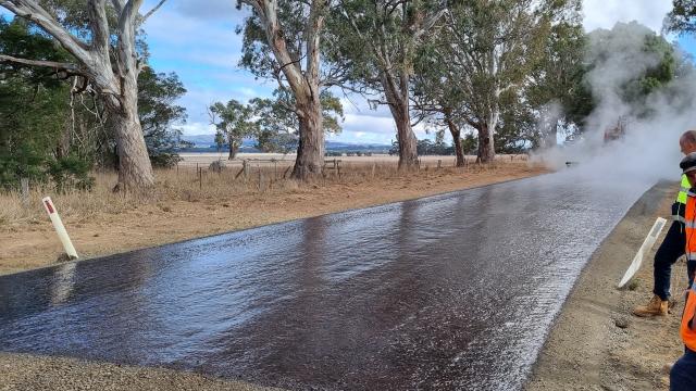  A road crew applies a fresh spray seal of bitumen to a rural road in Ararat, Victoria. 