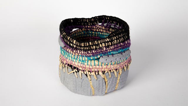 A brightly coloured, unusually-shaped artwork of ceramic and woven fibres