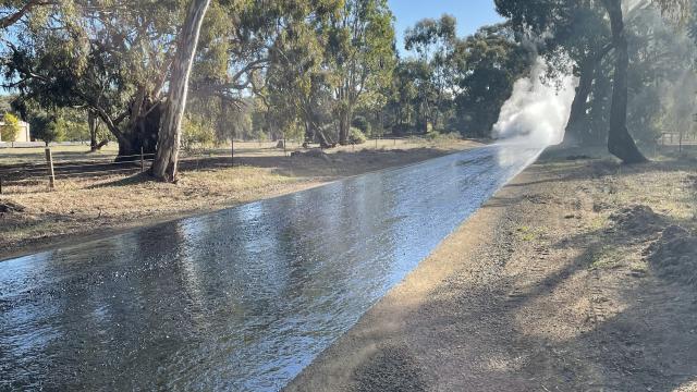 Long shot of a rural road with freshly laid rubber surface
