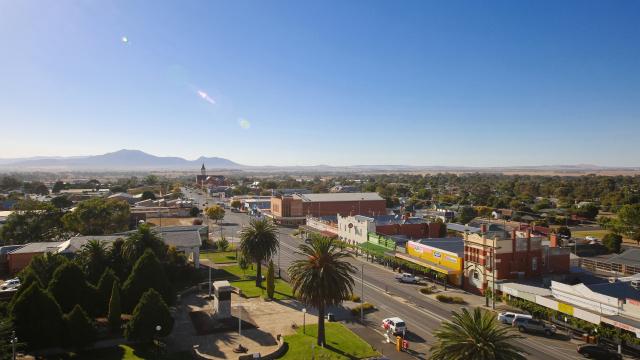 Long shot of a rural township on a sunny day with mountains in the background