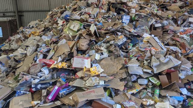 Large pile of clean recycling materials including cardboard and plastics