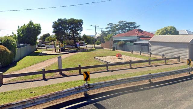 A suburban street with a small park attached