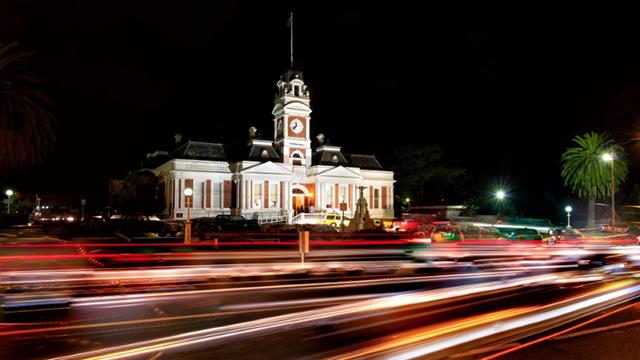 Large stately town hall at night time with lights
