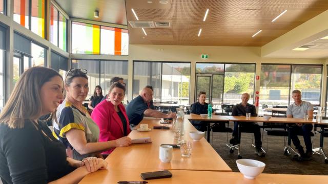 A group of meeting sitting at a meeting table in conversation