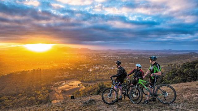 Three cyclists enjoy the views from One Tree Hill
