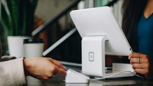 a hand touching a credit card to an EFTPOS terminal