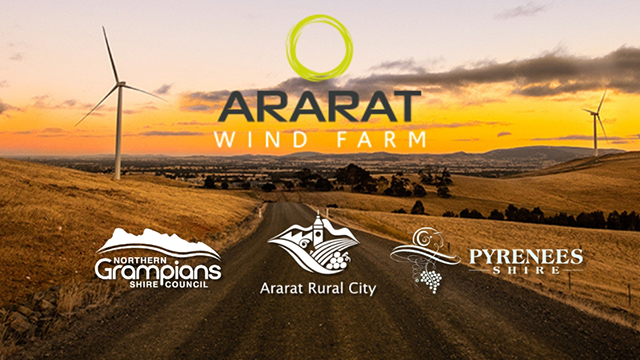 A rural road with a windfarm in the background, and the logos for three councils