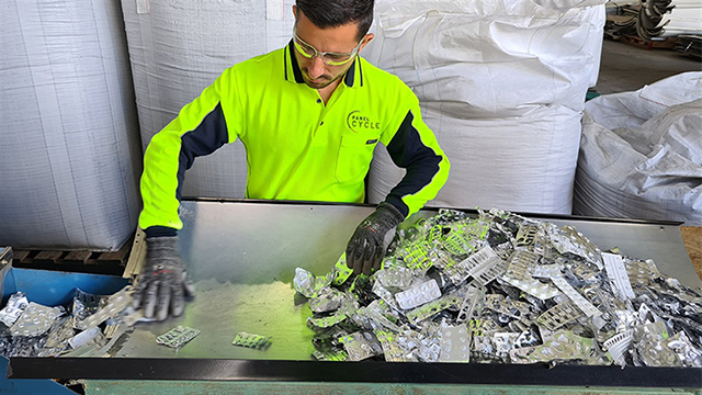 Man in hi-vis sorting blister packets on a table